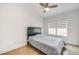 Neutral bedroom with light hardwood floors, a ceiling fan, and a large window that provides ample natural light at 603 Old Peachtree Ne Rd, Lawrenceville, GA 30043