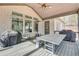 Inviting covered deck featuring an outdoor dining table and grill, perfect for entertaining or enjoying the natural surroundings at 603 Old Peachtree Ne Rd, Lawrenceville, GA 30043