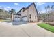 Home exterior showcasing a three-car garage and expansive driveway and landscaped yard at 603 Old Peachtree Ne Rd, Lawrenceville, GA 30043