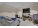 Spacious basement with carpet, a gray sofa, large TV, and exercise equipment at 1421 Hedgewood Nw Ln, Kennesaw, GA 30152