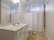 Bright bathroom with a white vanity, shower with curtain, and neutral tile flooring at 1421 Hedgewood Nw Ln, Kennesaw, GA 30152