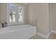 Elegant bathroom featuring a soaking tub with shuttered windows and a separate shower with glass door at 1421 Hedgewood Nw Ln, Kennesaw, GA 30152