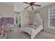 Charming bedroom featuring a white bed with crown canopy, ceiling fan, and natural light from two windows at 1421 Hedgewood Nw Ln, Kennesaw, GA 30152