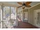 Relaxing screened porch with wood floors, ceiling fan, and views of the stone exterior of the home at 1421 Hedgewood Nw Ln, Kennesaw, GA 30152