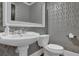 Stylish powder room featuring silver geometric wallpaper, pedestal sink, and white framed mirror at 1421 Hedgewood Nw Ln, Kennesaw, GA 30152