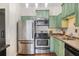Bright kitchen with stainless appliances, updated countertops, and green cabinets at 3060 Pharr Court North Nw # 619, Atlanta, GA 30305