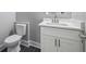 A bathroom features a white toilet, vanity with a sink, and dark tile flooring at 3200 Tackett Rd, Douglasville, GA 30135