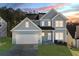 Charming two-story home boasts a two-car garage, classic architectural style, and verdant landscaping at 3200 Tackett Rd, Douglasville, GA 30135
