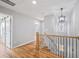 Bright hallway with hardwood floors, staircase, and modern light fixture at 3200 Tackett Rd, Douglasville, GA 30135