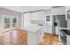 Bright eat-in kitchen featuring white cabinets, stainless appliances, hardwood floors, and large island with quartz countertops at 3200 Tackett Rd, Douglasville, GA 30135