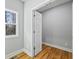 A room with hardwood floors and gray walls features a window and a white door at 3200 Tackett Rd, Douglasville, GA 30135
