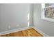 Room shows hardwood floors, white trim, a window, and gray walls with outlets at 3200 Tackett Rd, Douglasville, GA 30135