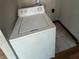 A white washing machine positioned on a tile floor, set against a neutral wall, ready for laundry needs at 4707 Mariners Way, Stone Mountain, GA 30083