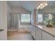 Well-lit bathroom featuring a granite vanity top, tub, and glass-enclosed shower at 1856 Kingsmere Run Dr, Loganville, GA 30052