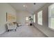 Bright bedroom sitting area with two chairs and artwork; natural light shines through large windows at 1856 Kingsmere Run Dr, Loganville, GA 30052