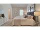 Bedroom featuring a tufted headboard, plush bedding, and abundant natural light from a large window at 1856 Kingsmere Run Dr, Loganville, GA 30052