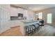 Island kitchen featuring stainless steel appliances, granite countertops, gray tile backsplash, and hardwood floors at 1856 Kingsmere Run Dr, Loganville, GA 30052
