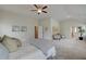 Spacious bedroom with seating area, ensuite bath, and a ceiling fan at 1856 Kingsmere Run Dr, Loganville, GA 30052