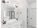 Well-lit bathroom featuring a double vanity, framed mirror, and a marble-walled shower at 3278 Greenhill Dr, Villa Rica, GA 30180