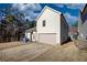View of the house's backyard with a paved driveway and a two-car garage at 5114 Arnold St, Covington, GA 30014