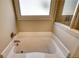 Elegant bathtub featuring a window for natural light, next to the enclosed shower at 5114 Arnold St, Covington, GA 30014