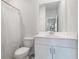 Well lit bathroom featuring a large mirror, white vanity, toilet and shower at 849 Sara Meadow Rd, Loganville, GA 30052