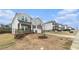 View of a charming gray and stone two-story home with a two car garage in a residential neighborhood at 849 Sara Meadow Rd, Loganville, GA 30052