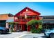 Bright red building with second-story balcony, flags, and greenery enhancing the charming exterior at 164 Oxbo Rd, Roswell, GA 30075