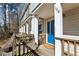 Inviting front porch featuring a vibrant blue door, wooden railings, and a welcoming mat at 164 Oxbo Rd, Roswell, GA 30075