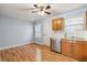 Cozy kitchen featuring wood cabinets, stainless steel dishwasher, and durable laminate flooring at 164 Oxbo Rd, Roswell, GA 30075