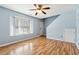 Bright living room features hardwood floors, a ceiling fan, large window and white trim at 164 Oxbo Rd, Roswell, GA 30075