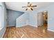 Open living room with hardwood floors, ceiling fan, staircase, and view into the kitchen at 164 Oxbo Rd, Roswell, GA 30075