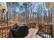 Back deck with grill and wooded view offers a spot for outdoor entertaining at 122 Little Ridge Rd, Berkeley Lake, GA 30096