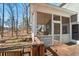 View from stairs to the screen porch with seating and ceiling fan with wood railing at 122 Little Ridge Rd, Berkeley Lake, GA 30096