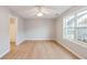 A bedroom with light gray walls, laminate floors, a ceiling fan, and an open door to a bathroom at 129 Prospect Path, Hiram, GA 30141