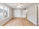 A bright bedroom with a large window, ceiling fan, laminate floors, and double door closet at 129 Prospect Path, Hiram, GA 30141
