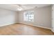 A spacious bedroom with laminate floors, light gray walls, a ceiling fan, and a large window at 129 Prospect Path, Hiram, GA 30141
