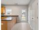 A kitchen with a breakfast bar island, tile floors, light wood cabinets, and a door to the backyard at 129 Prospect Path, Hiram, GA 30141