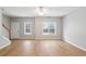 Bright and airy living room featuring wood-look flooring, a ceiling fan, and natural light from large windows at 129 Prospect Path, Hiram, GA 30141