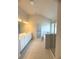 Bright bathroom with double vanity, tiled floors, bathtub, and glass-enclosed shower at 1847 Kingsmere Run Dr, Loganville, GA 30052