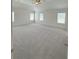 A large bedroom with neutral carpeting and walls boasts a ceiling fan and many windows at 1847 Kingsmere Run Dr, Loganville, GA 30052