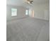 A large bedroom that boasts a neutral color palette, plush carpet, and a ceiling fan at 1847 Kingsmere Run Dr, Loganville, GA 30052