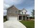 Charming two-story home featuring a classic brick facade, inviting front porch and attached two car garage at 1847 Kingsmere Run Dr, Loganville, GA 30052