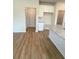 Bright eat-in kitchen boasts a large granite island, white cabinetry, and wood flooring at 1847 Kingsmere Run Dr, Loganville, GA 30052