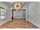 Dining area features wood floors, decorative wall trim, modern light fixture, and view into other rooms at 270 New Hope Rd, Lawrenceville, GA 30046