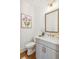 Elegant half bathroom features a vanity with gold fixtures and a decorative floral print at 106 Cottage Gate Ln, Roswell, GA 30076