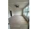 Large room with white paneled accent wall, modern fan, and lots of windows at 106 Cottage Gate Ln, Roswell, GA 30076