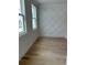 Cozy room with light hardwood floors, lots of light, and a geometric accent wall at 106 Cottage Gate Ln, Roswell, GA 30076