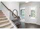 Elegant entryway featuring a stylish console table, round mirror, and staircase with carpeted steps at 428 Madison Lakeview Dr, Acworth, GA 30102