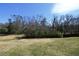 A large backyard with grassy area and mature trees with clear blue skies at 900 King Rd, Jonesboro, GA 30236